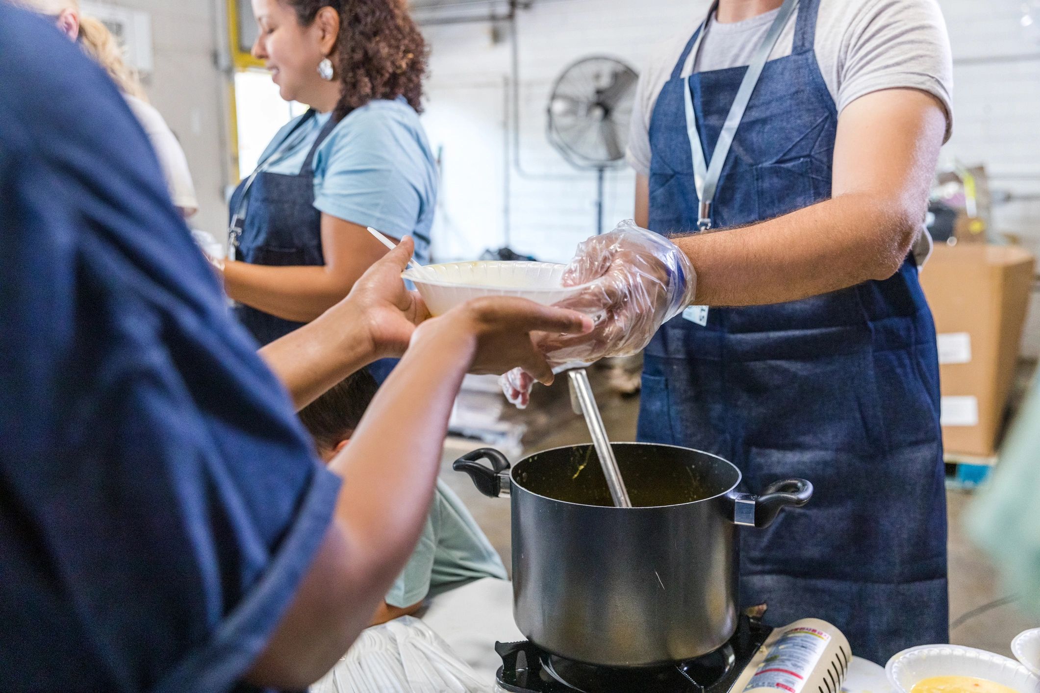 Soup being served to a woman in need