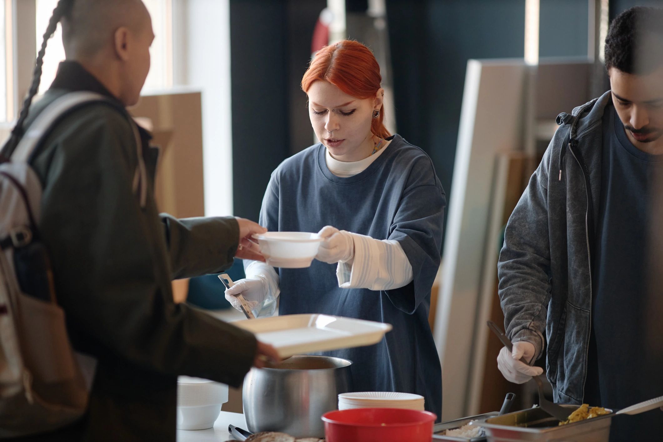 Volunteer serving soup at a humanitarian aid center